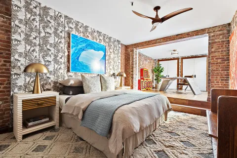 a view of a bedroom with a bed and wooden floor