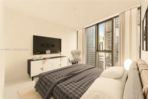 a bedroom with a bed television window and couch