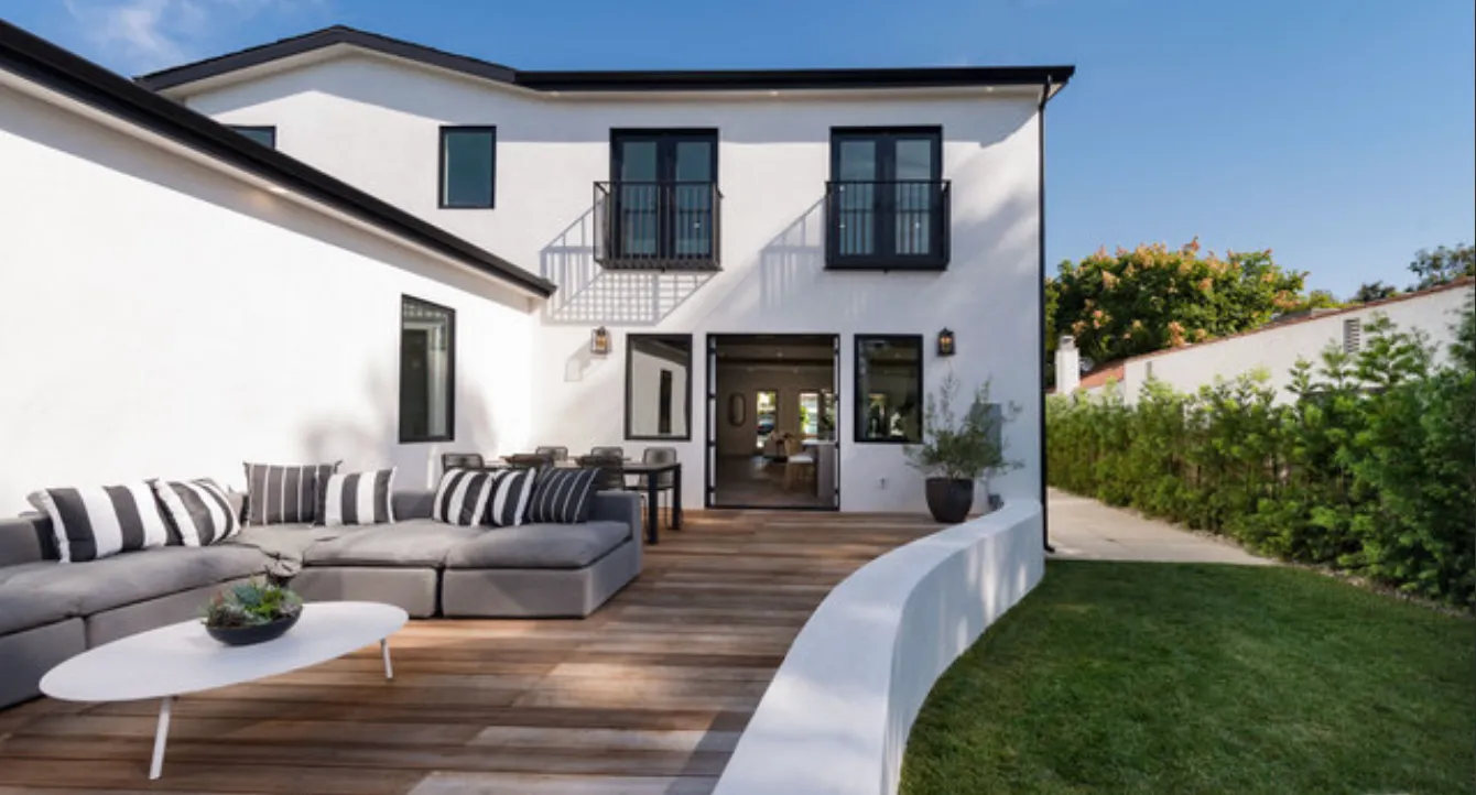 a view of a patio with couches table and chairs and potted plants