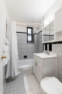 a bathroom with a sink and mirror with bathtub