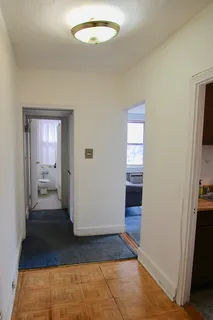 a view of a hallway view with wooden floor and a bathroom