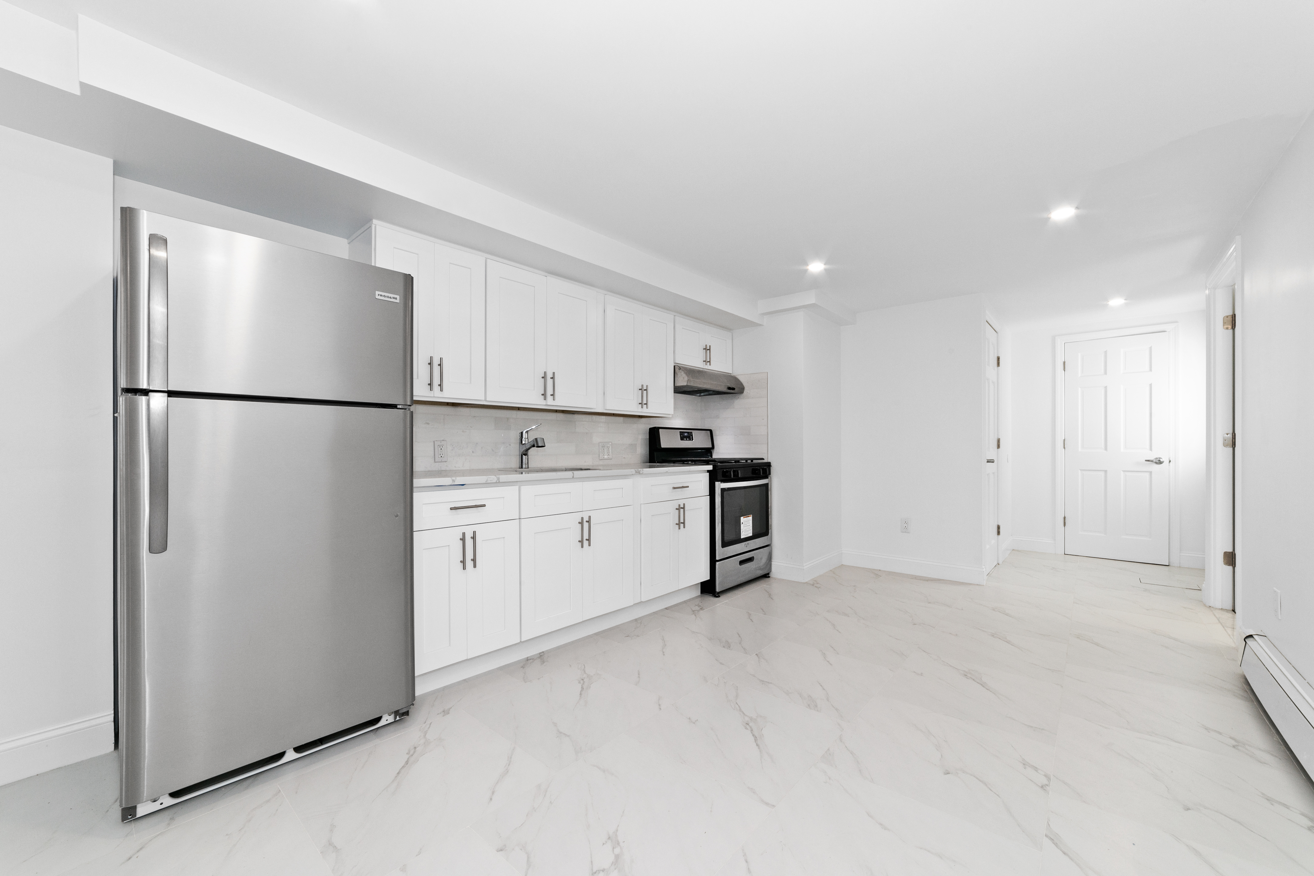24-41 82nd Street Queens, NY 11370 - Photo 8 of 15 a white refrigerator freezer sitting in a kitchen