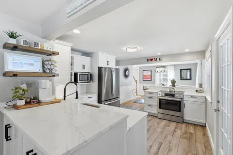 a kitchen with kitchen island a refrigerator stove and sink