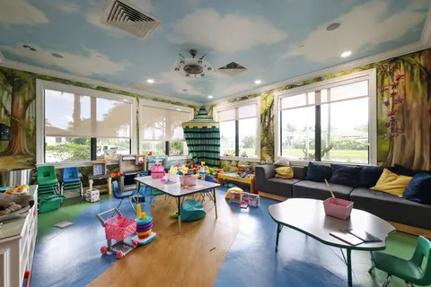 a living room with furniture and floor to ceiling windows
