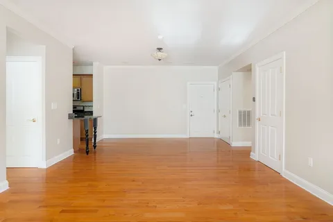 a view of empty room with wooden floor
