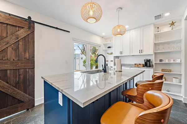 a kitchen with stainless steel appliances granite countertop a sink a stove and a wooden floors