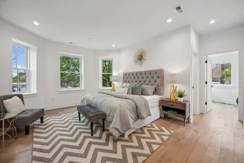 a bedroom with a bed and wooden floor