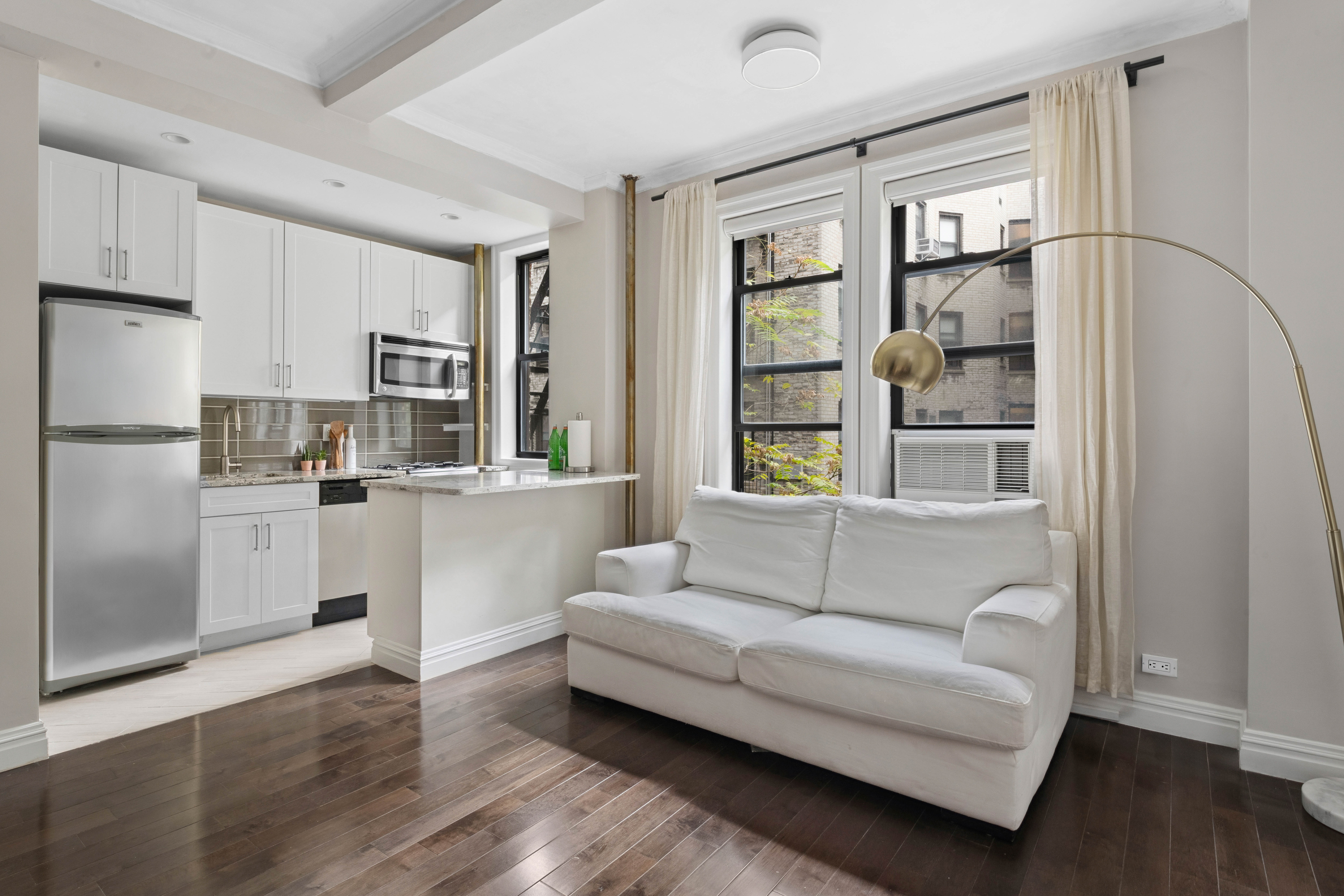 17 West 64th Street, Unit 4E Manhattan, NY 10023 - Photo 2 of 9 a living room with stainless steel appliances furniture and a window