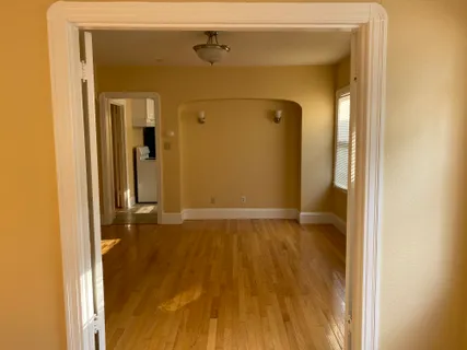 a view of empty room with wooden floor