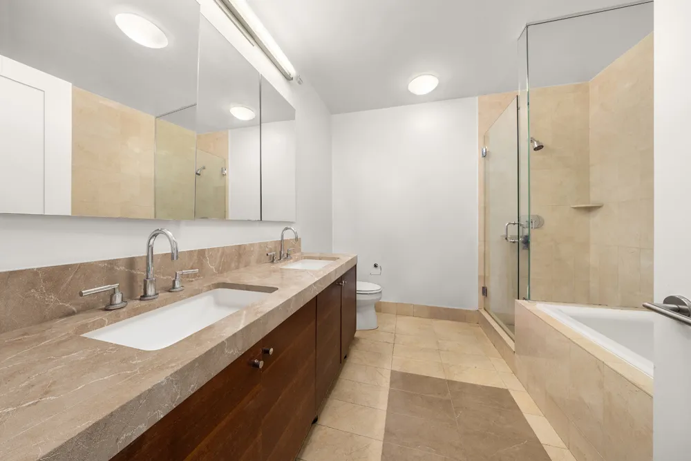 a spacious bathroom with a granite countertop sink mirror and a bathtub