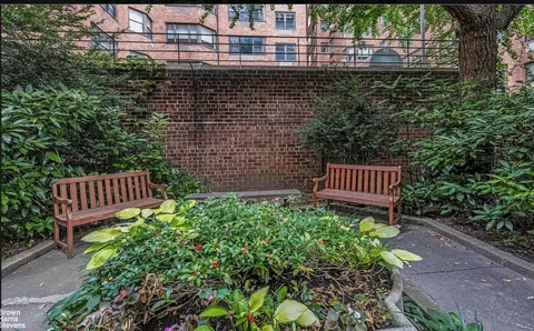 a view of a back yard of a house with a bench