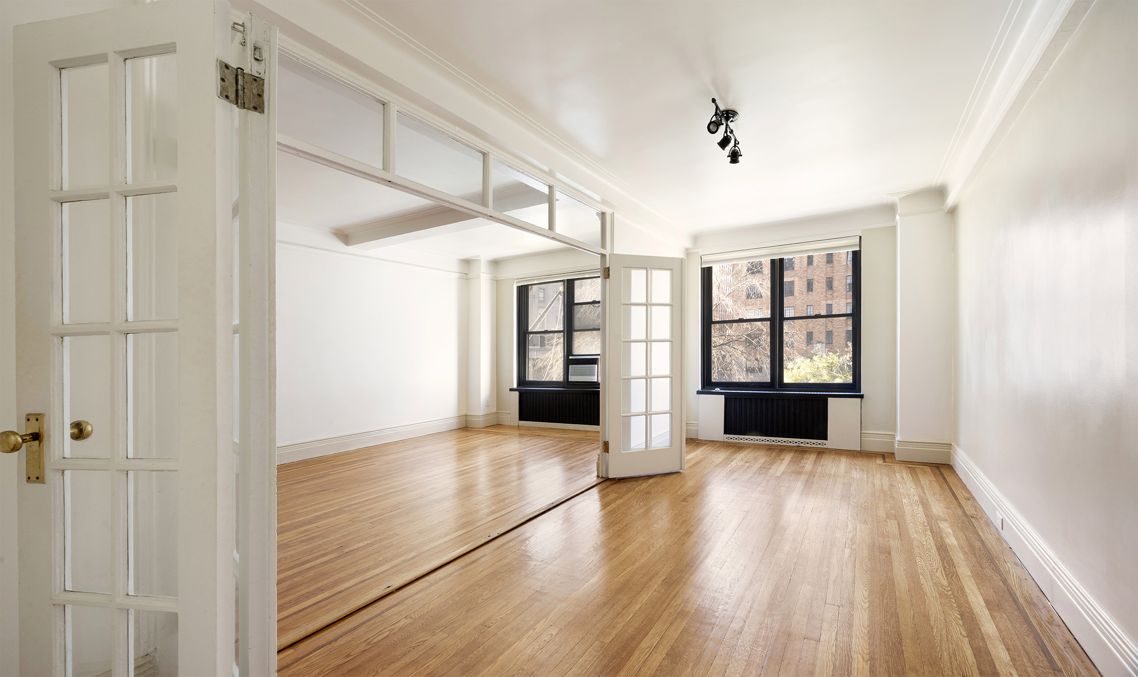 7 Park Avenue, Unit 41 Manhattan, NY 10016 - Photo 2 of 9 a view of an empty room with wooden floor and a window