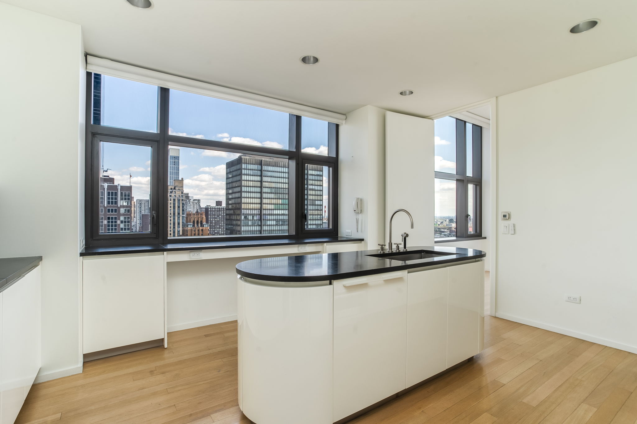 50 United Nations Plaza, Unit 26B Manhattan, NY 10017 - Photo 10 of 25 a view of kitchen with stainless steel appliances granite countertop a sink and a wooden floors