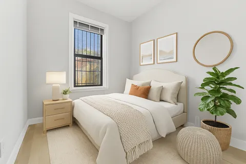 a bedroom with a bed and a potted plant
