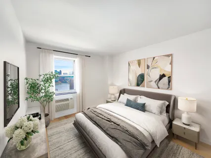 a bedroom with a large bed and a potted plant