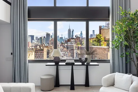 a view of two chairs and a potted plant in front of a door