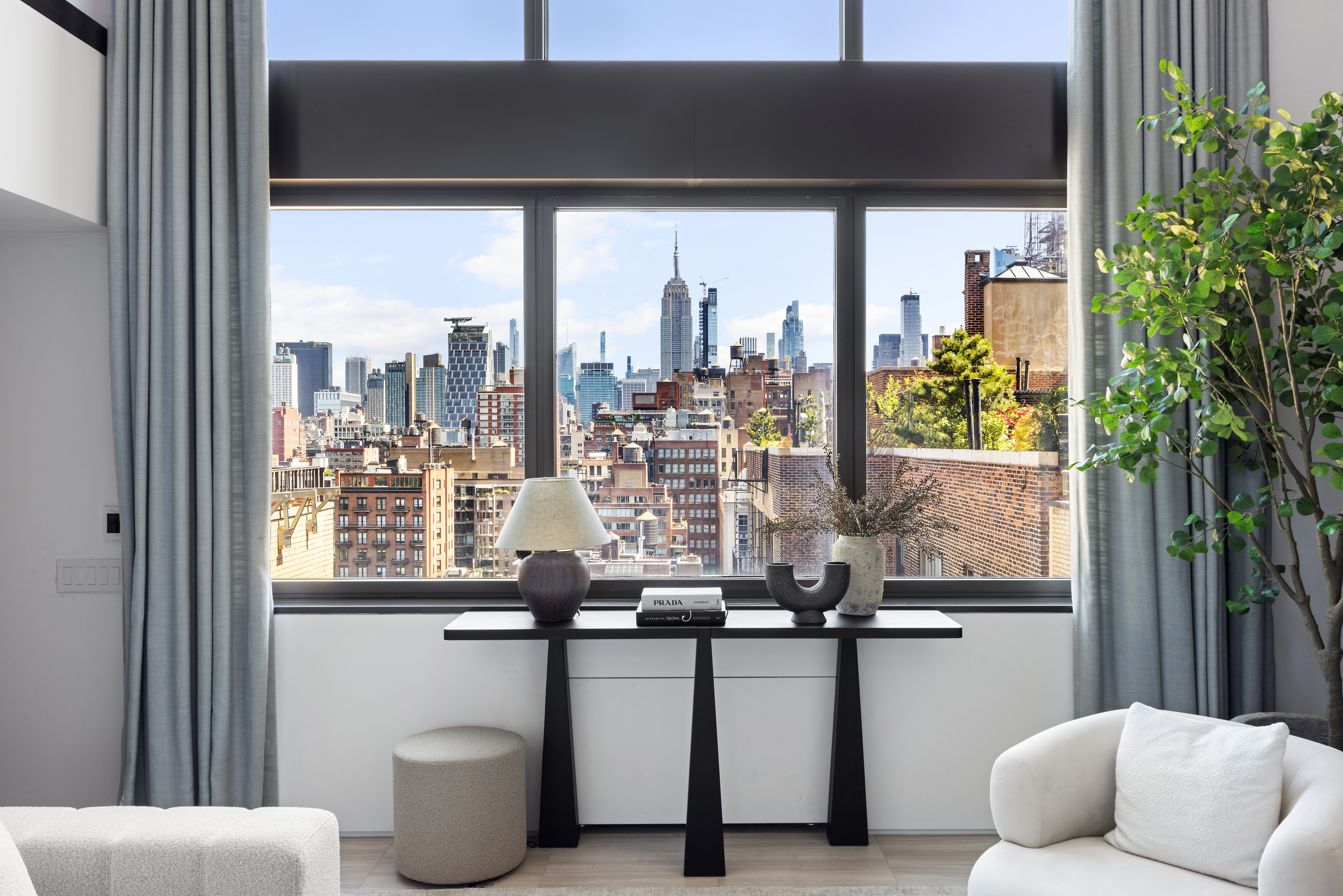 24 5th Avenue, Unit PH1701 Manhattan, NY 10011 - Photo 5 of 24 a view of two chairs and a potted plant in front of a door