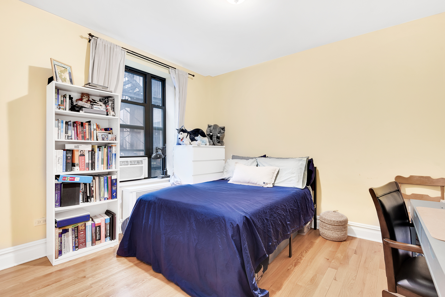 750 Riverside Drive, Unit 3E Manhattan, NY 10031 - Photo 5 of 8 a bedroom with a bed furniture and a book shelf