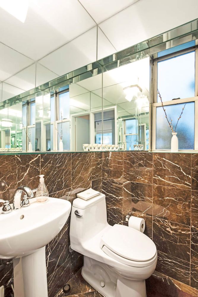 520 East 76th Street, Unit PHC Manhattan, NY 10021 - Photo 10 of 15 a bathroom with a sink a toilet and mirror