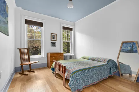 a bedroom with a bed chair and a window