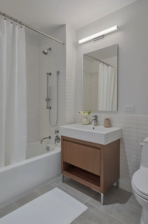 5 South 5th Street, Unit 913 Brooklyn, NY 11249 - Photo 5 of 24 a bathroom with a sink a toilet and shower