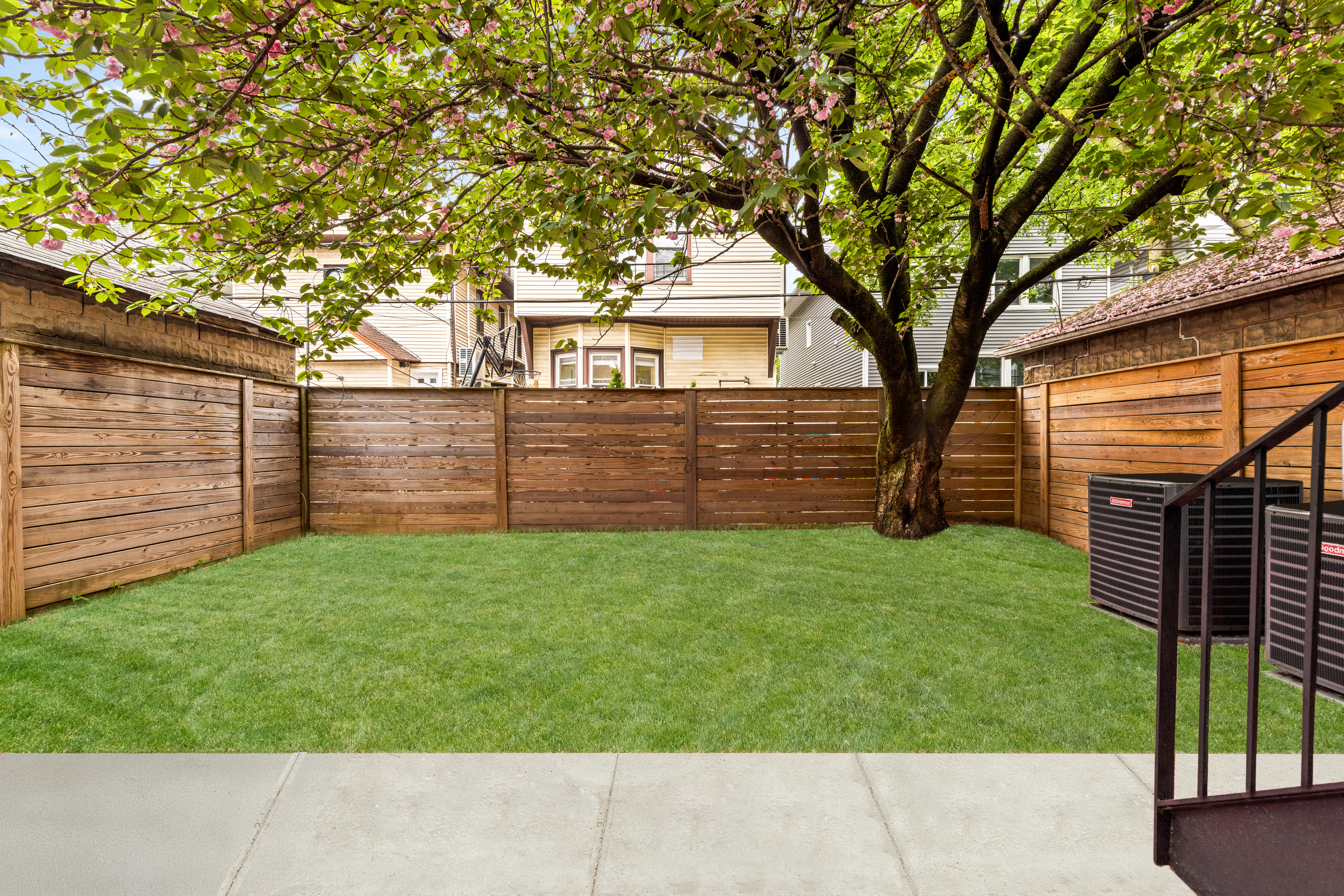 409 East 4th Street Brooklyn, NY 11218 - Photo 14 of 19 a view of a backyard with wooden fence and large trees