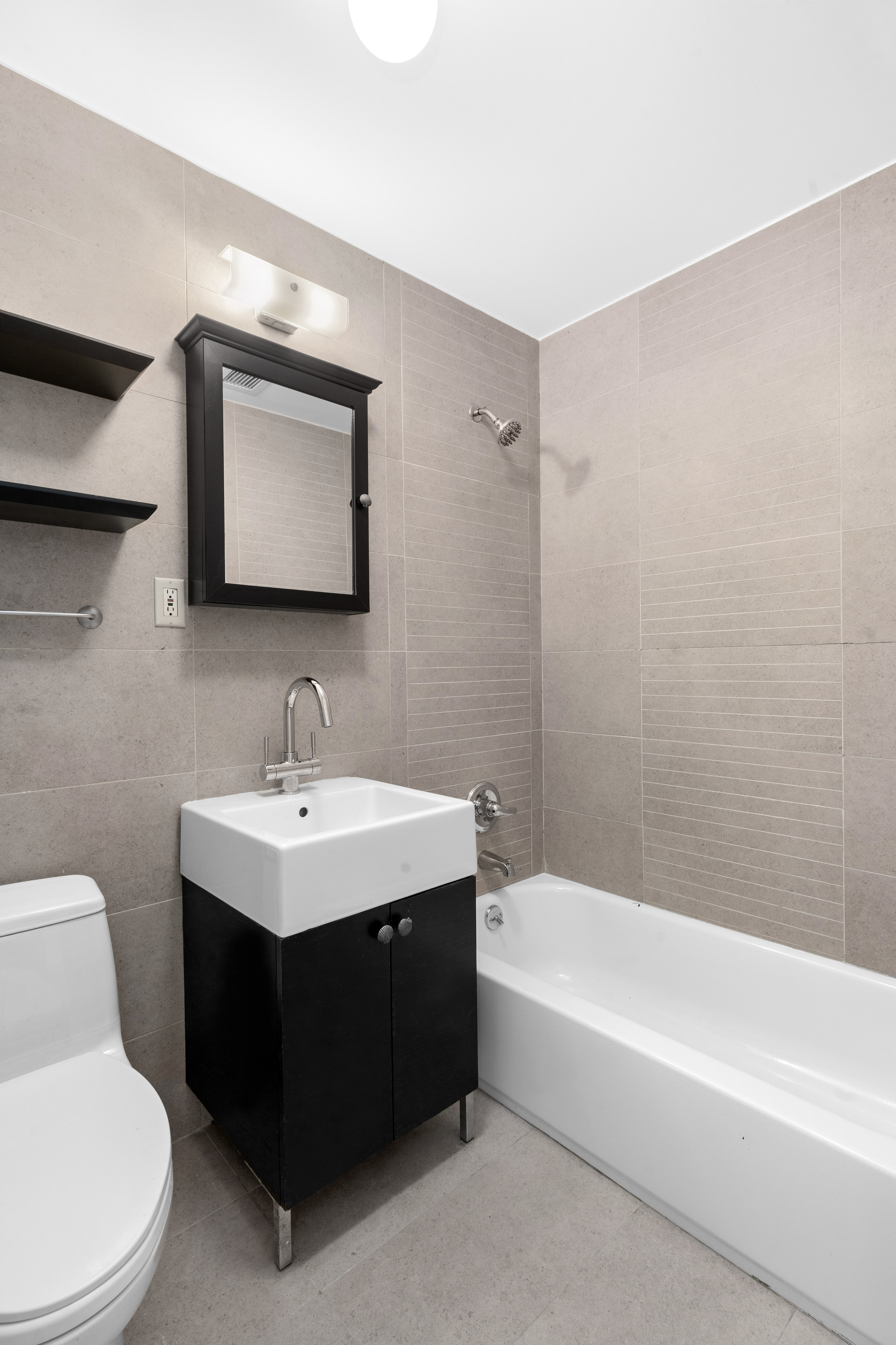 269 8th Street, Unit 2R Brooklyn, NY 11215 - Photo 10 of 14 a bathroom with a toilet a sink and mirror