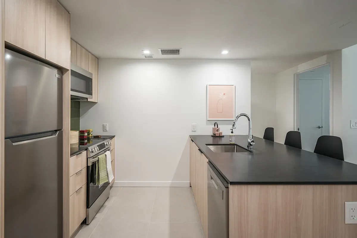 a kitchen with stainless steel appliances granite countertop a sink a refrigerator and a granite counter tops