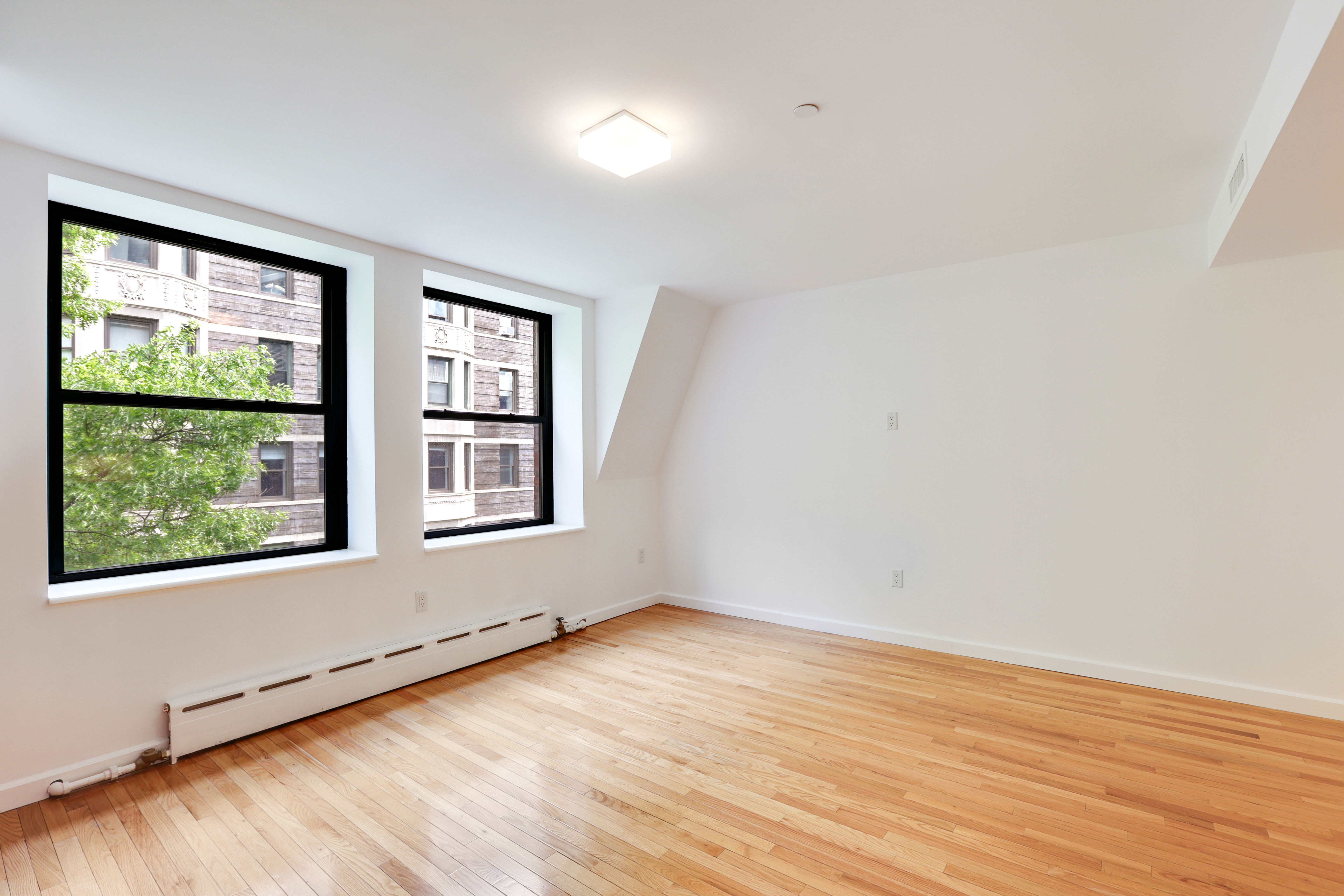 230 West 75th Street, Unit 4 Manhattan, NY 10023 - Photo 7 of 16 an empty room with wooden floor and windows