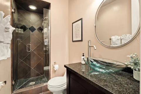 a bathroom with a granite countertop sink mirror and toilet
