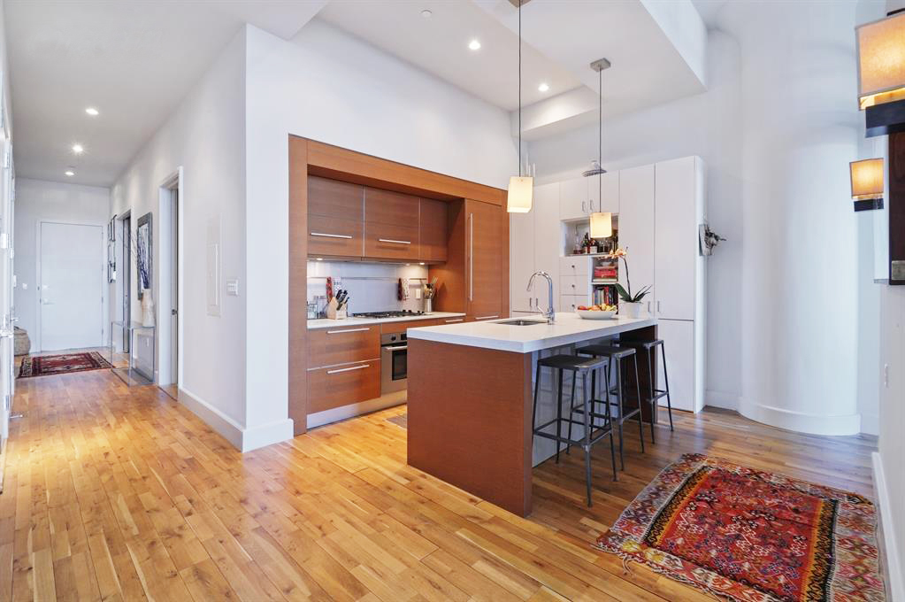 360 Furman Street, Unit 511 Brooklyn, NY 11201 - Photo 3 of 37 a kitchen with kitchen island stainless steel appliances a stove refrigerator sink and wooden floor
