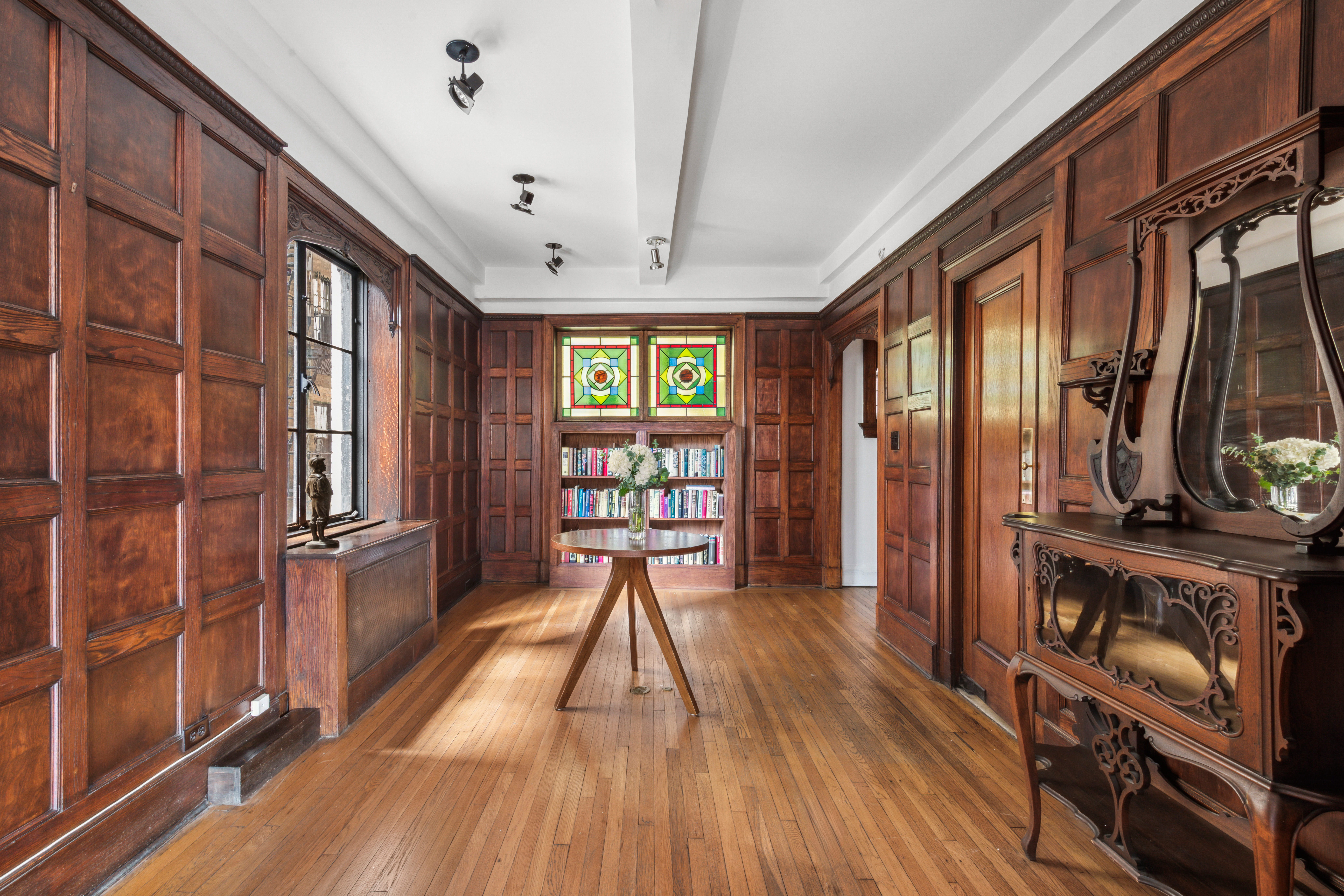 1 West 67th Street, Unit 501/502 Manhattan, NY 10023 - Photo 5 of 19 a hallway with wooden floor fireplace and windows