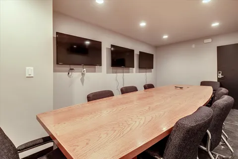 a living room with a flat screen tv and kitchen view