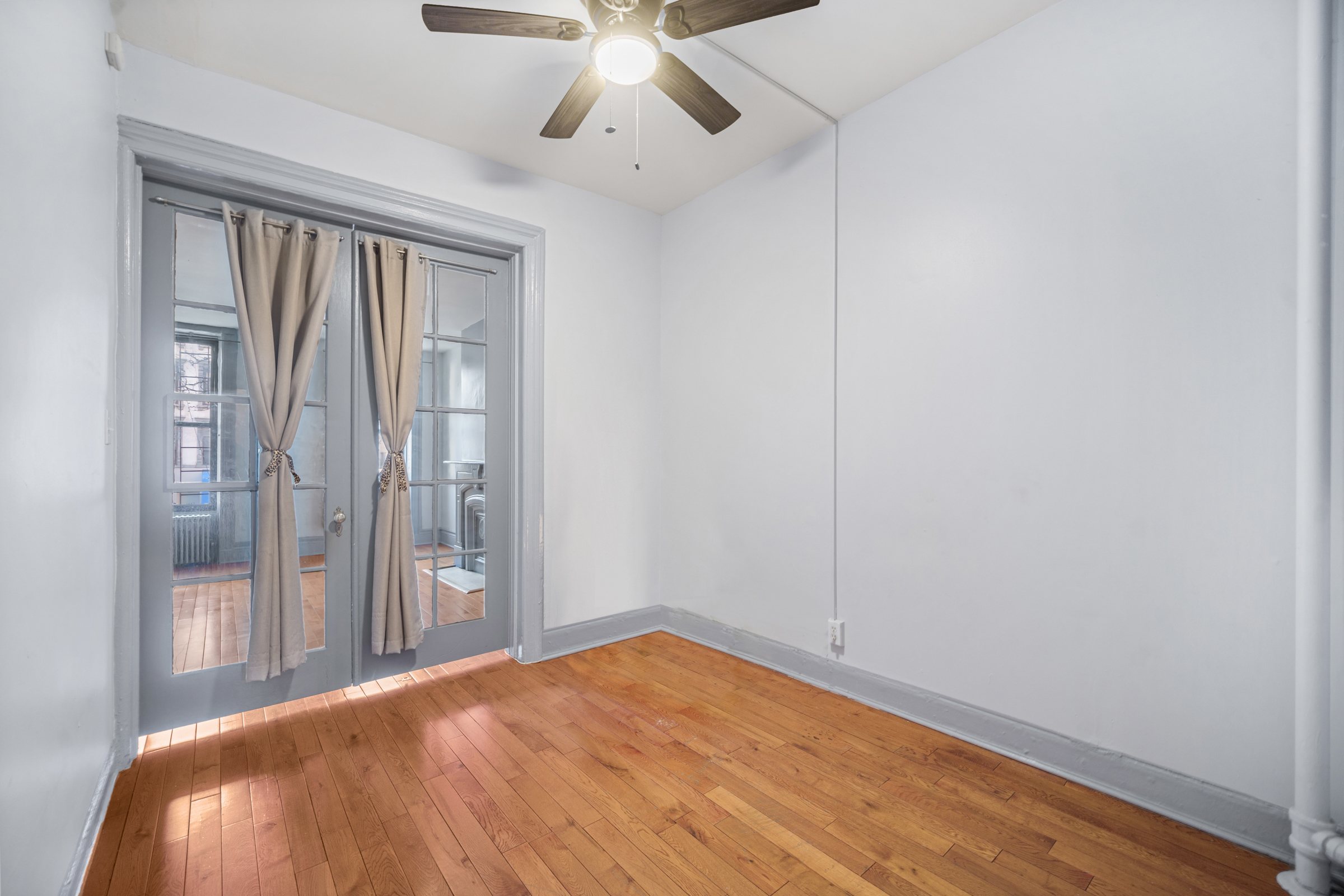 1663 1st Avenue, Unit 2S Manhattan, NY 10028 - Photo 4 of 6 a view of a room with wooden floor fan and windows