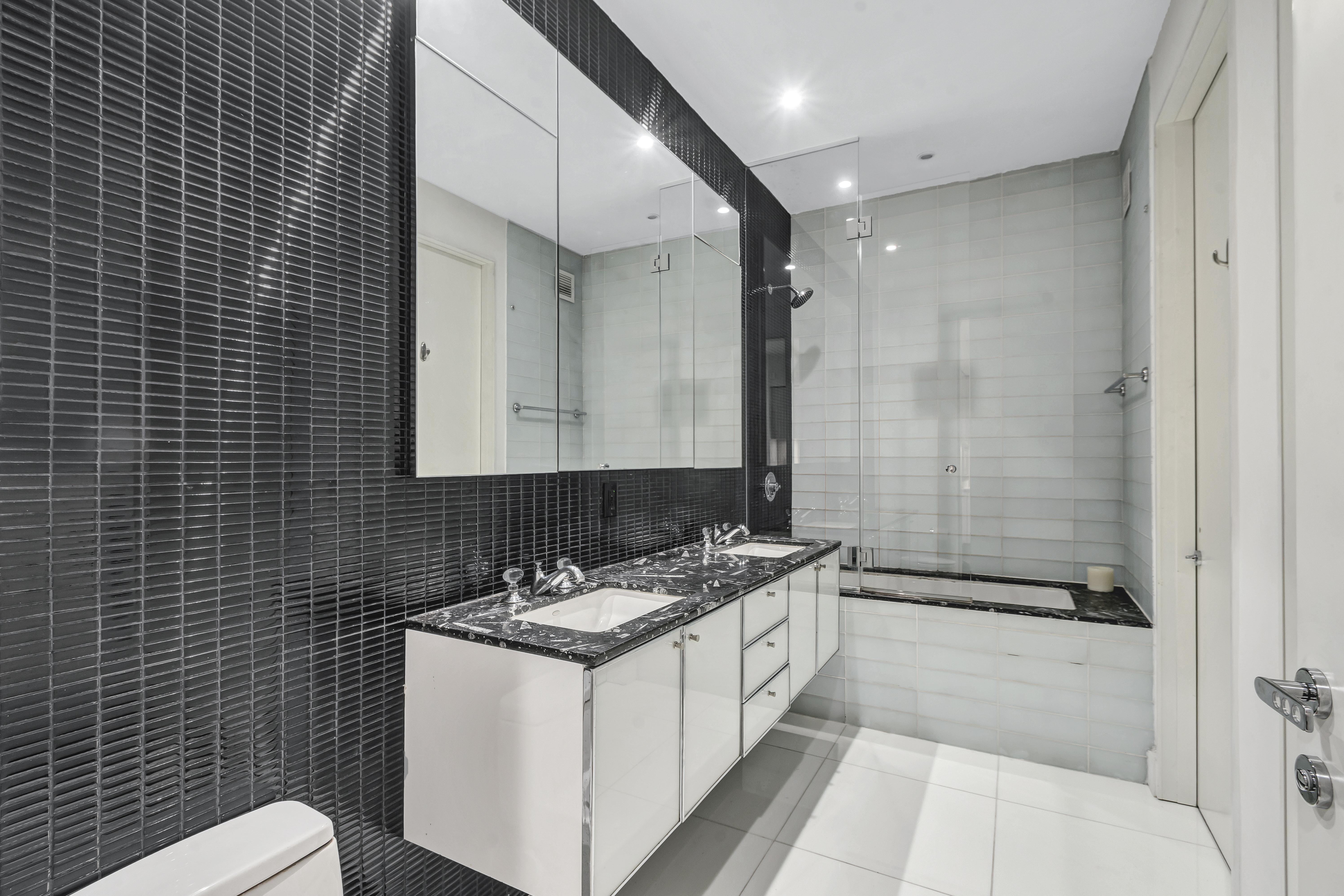 25 Broad Street, Unit 11K Manhattan, NY 10004 - Photo 7 of 16 a bathroom with a double vanity sink toilet and shower