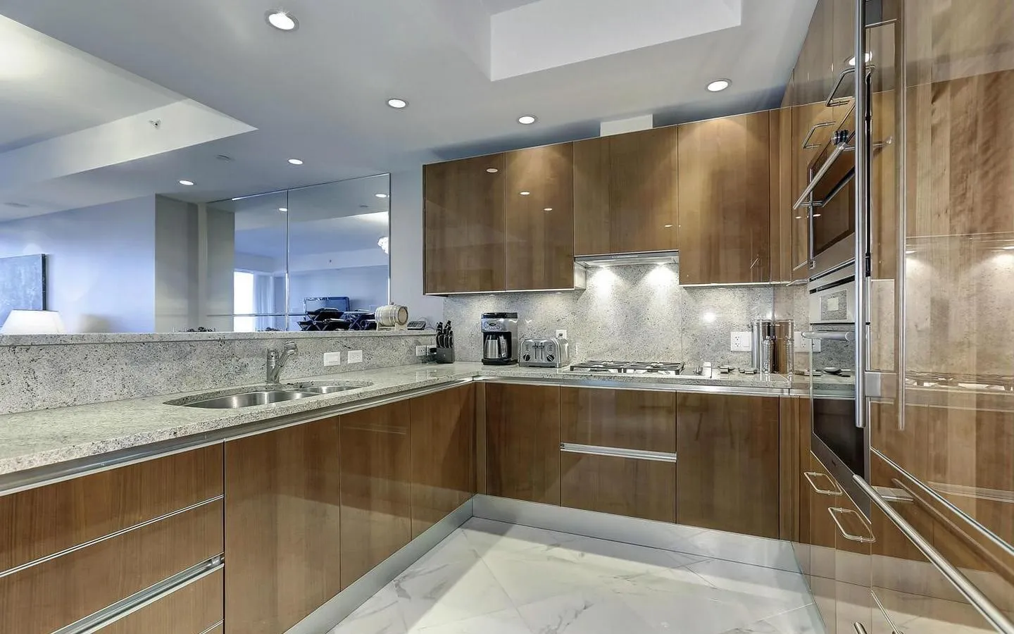 a kitchen with kitchen island granite countertop a sink stainless steel appliances and cabinets