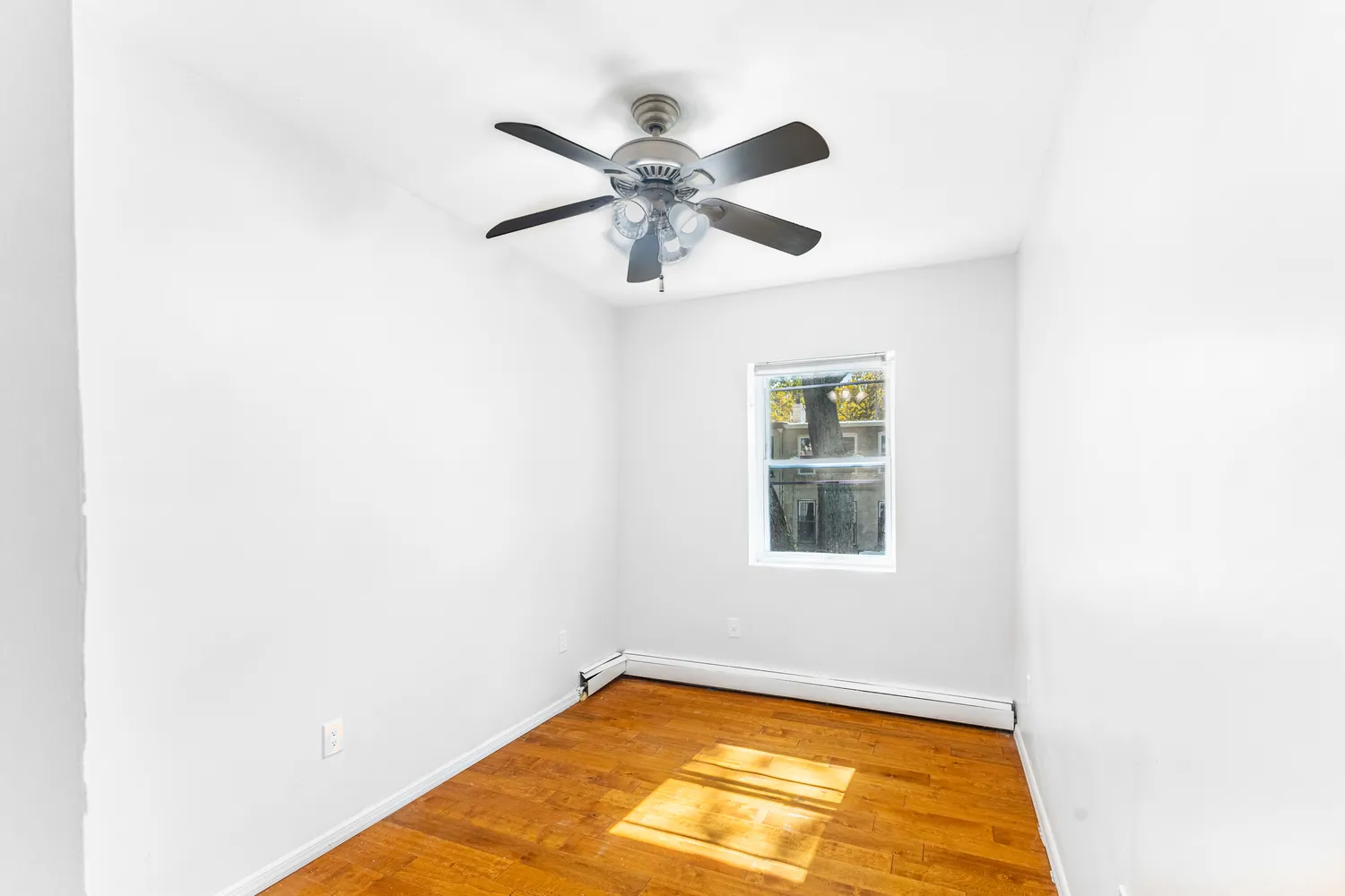 a view of a room with window and wooden floor