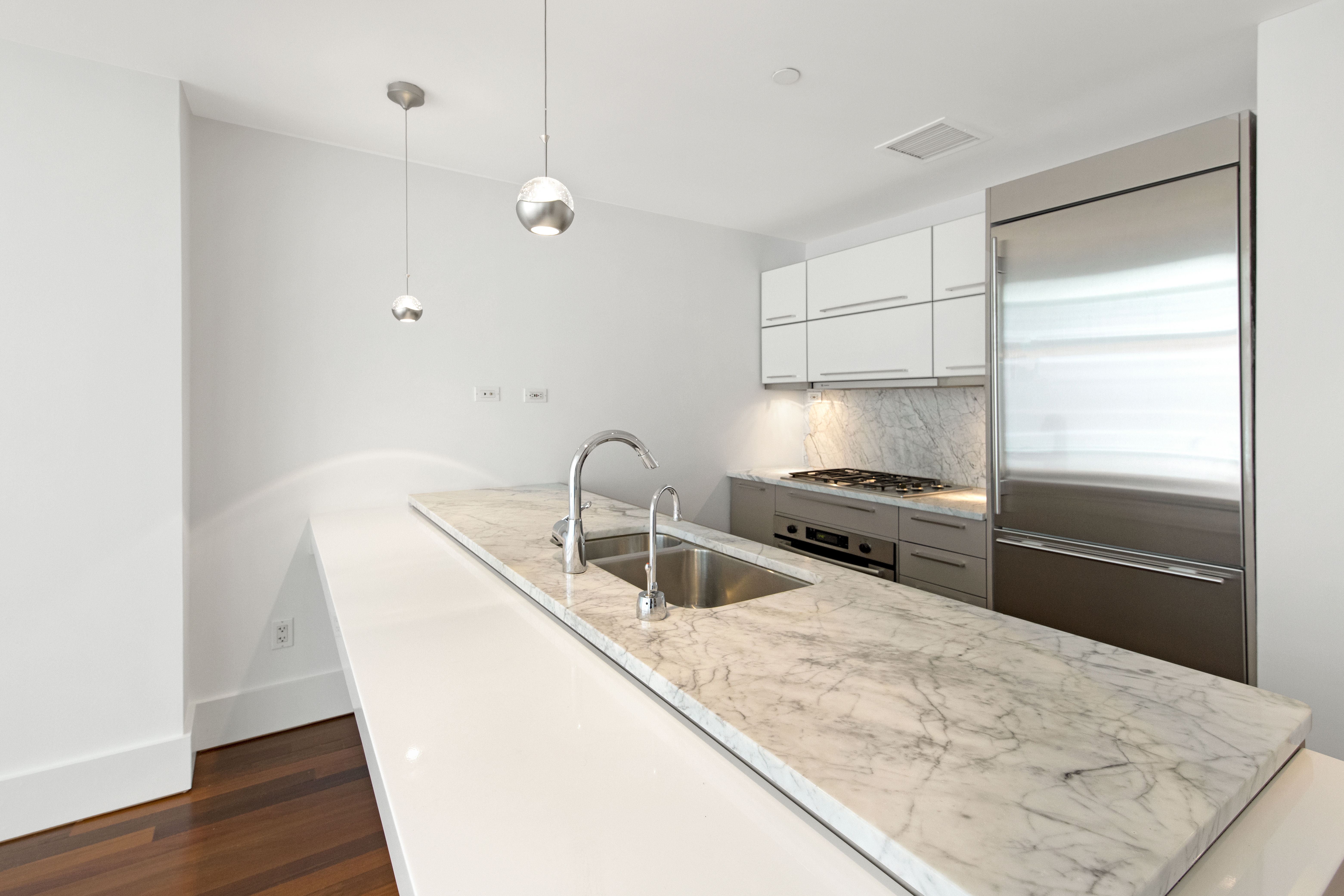 165 West 18th Street, Unit 8B Manhattan, NY 10011 - Photo 3 of 9 a kitchen with stainless steel appliances granite countertop a sink and a refrigerator
