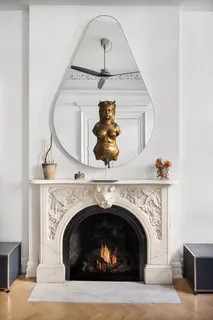 a living room with a fireplace and wooden floor