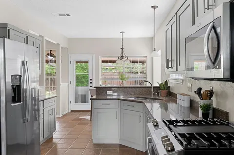 a kitchen with stainless steel appliances a sink stove and refrigerator