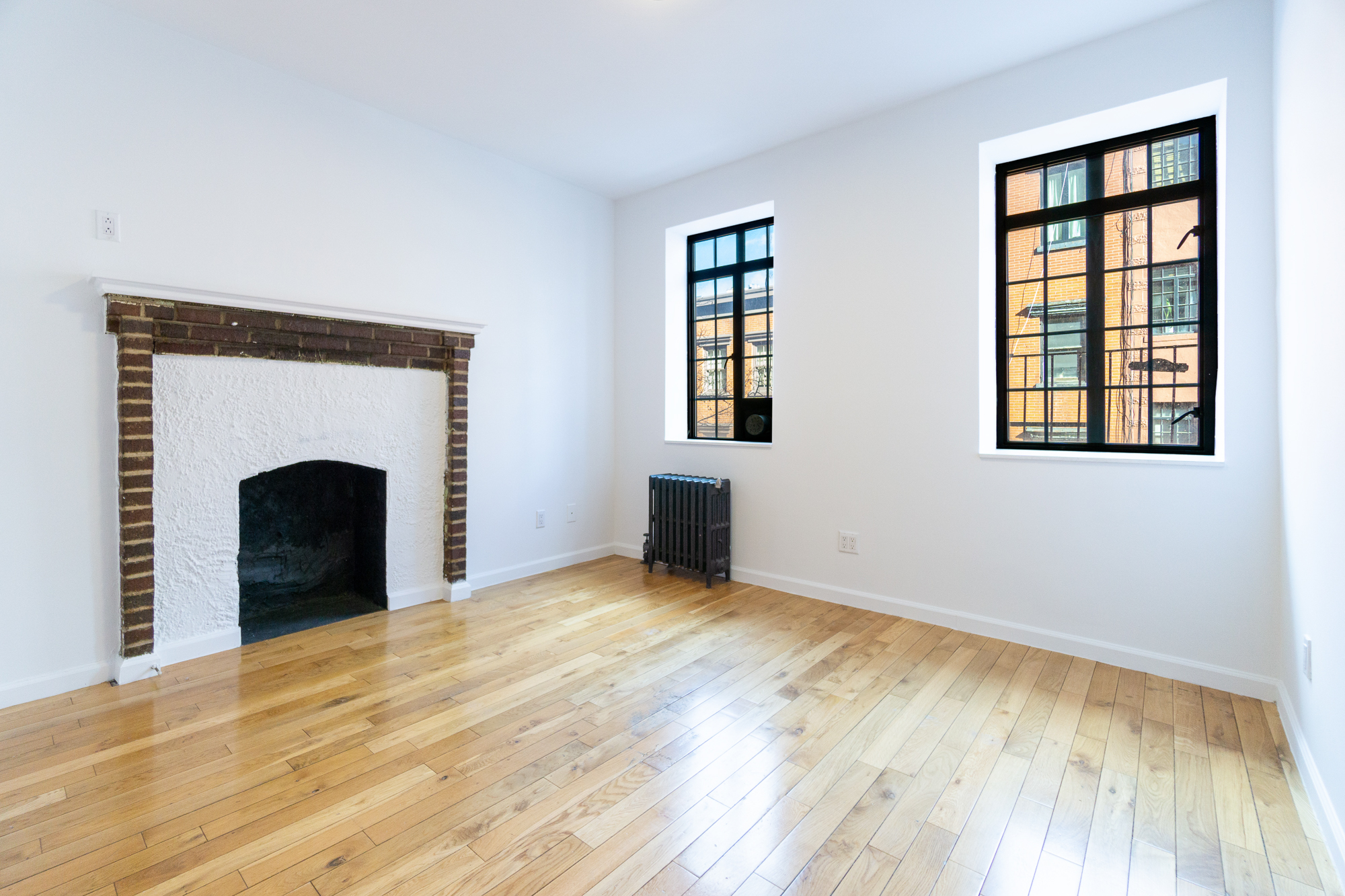 a view of an empty room with window and fire place