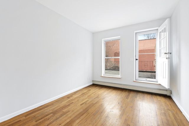 120 Smith Street, Unit 1 Brooklyn, NY 11201 - Photo 6 of 11 an empty room with wooden floor and windows