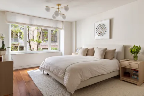 a bedroom with bed and a large window