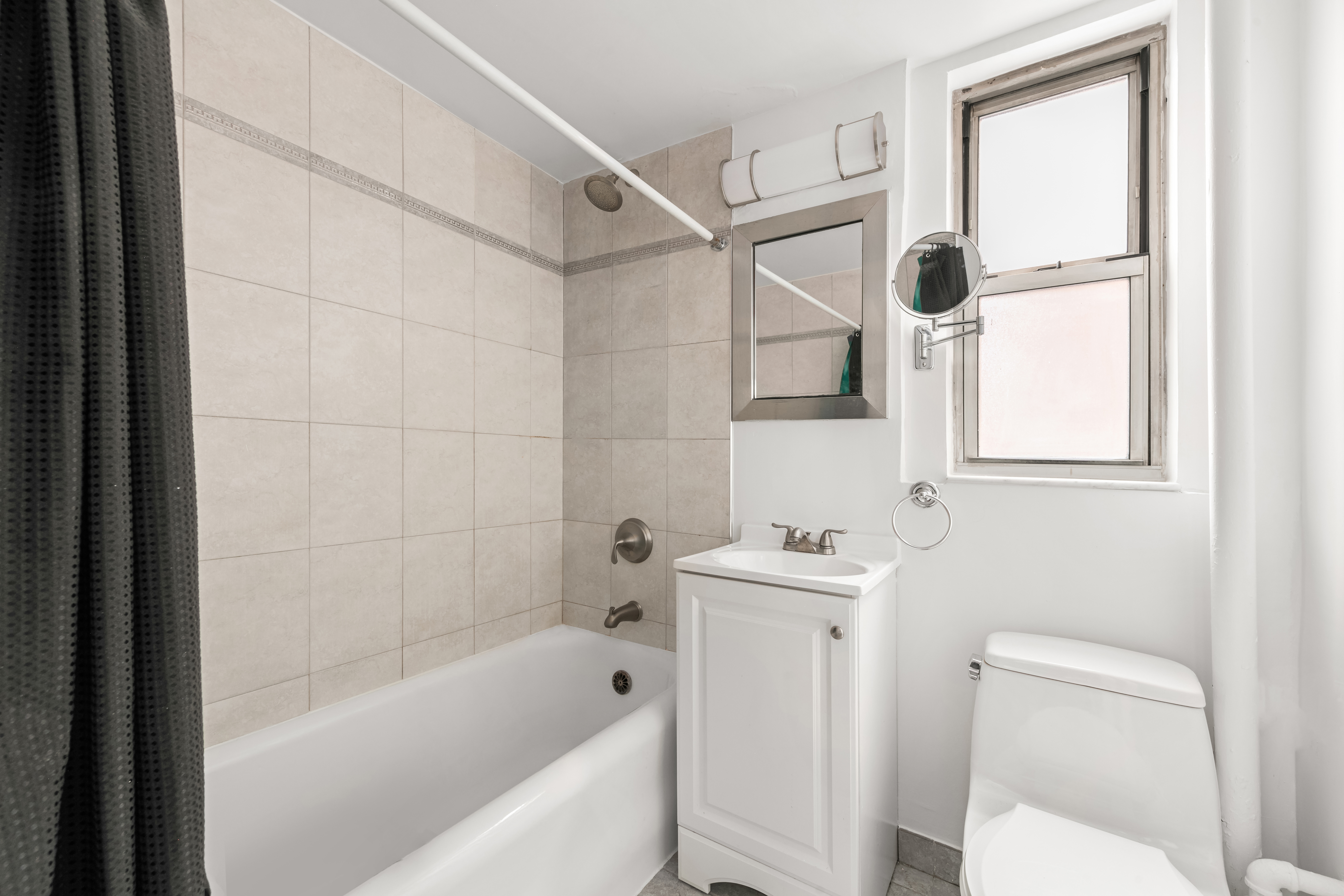 333 East 43rd Street, Unit 709 Manhattan, NY 10017 - Photo 5 of 15 a bathroom with a sink a toilet and shower