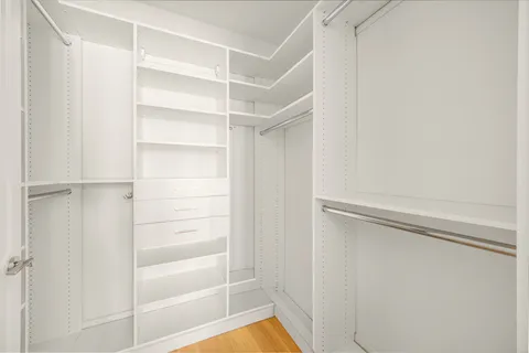 a view of walk in closet with empty racks