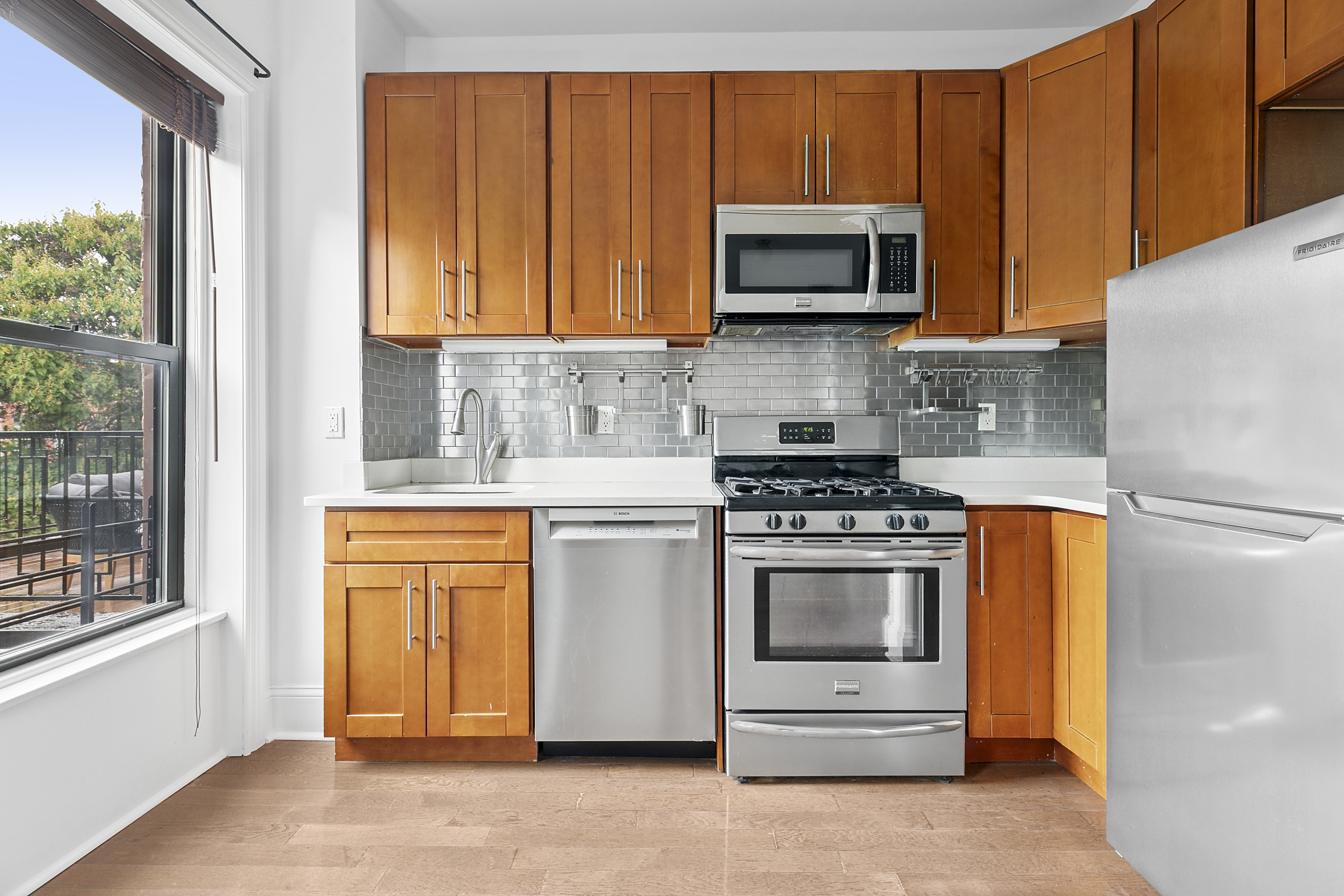68 Downing Street, Unit 2 Brooklyn, NY 11238 - Photo 2 of 8 a kitchen with stainless steel appliances granite countertop a stove microwave and refrigerator