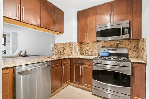 a kitchen with stainless steel appliances granite countertop a stove microwave and oven