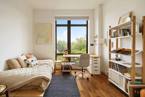 a bedroom with a bed and a book shelf