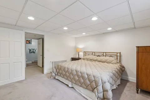 a bedroom with a bed and a refrigerator