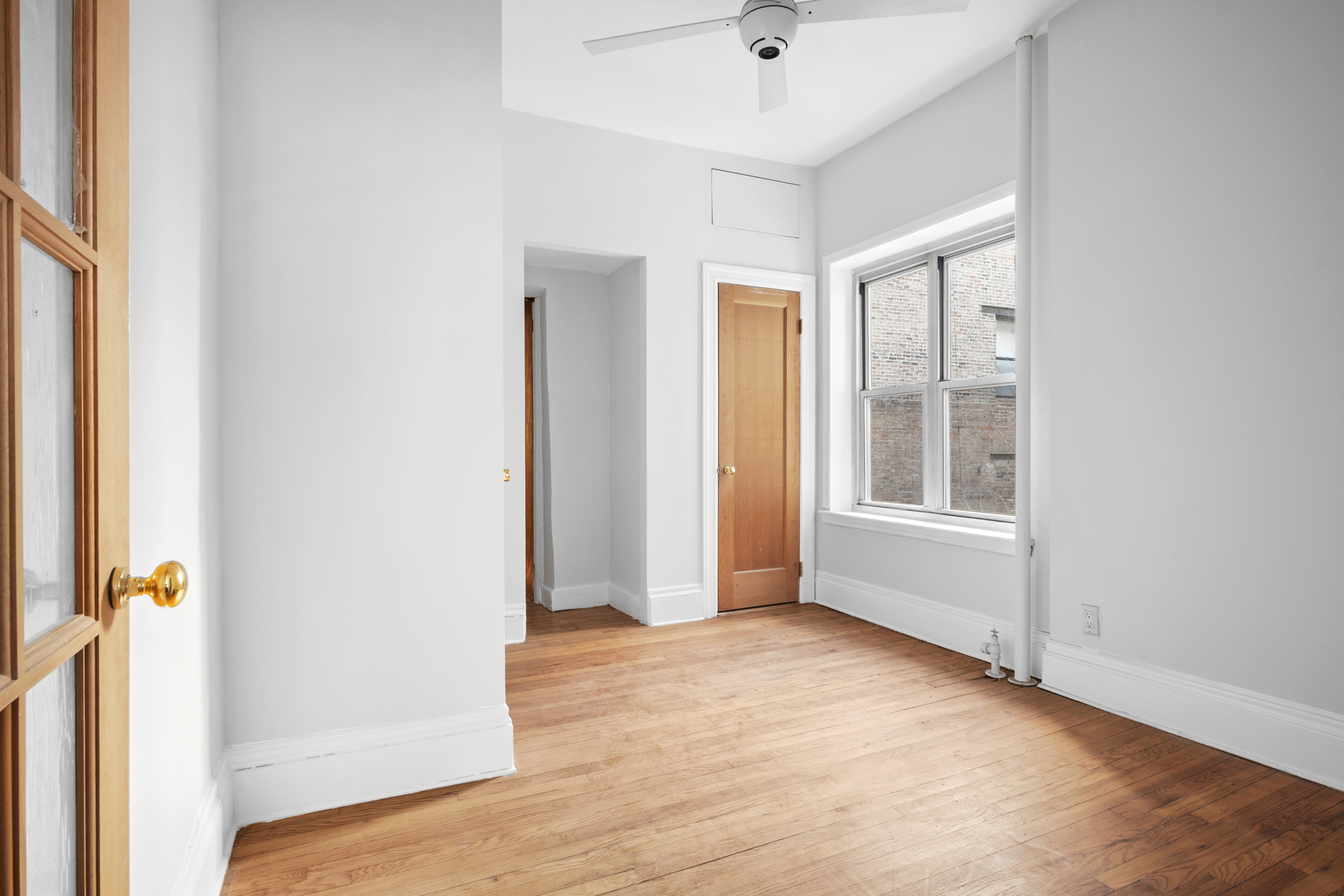 306 West 4th Street, Unit B1B2 Manhattan, NY 10014 - Photo 3 of 9 an empty room with wooden floor and windows